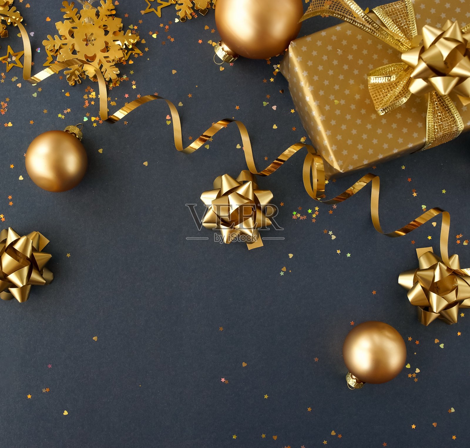 圣诞或新年礼盒和装饰在金色的深蓝背景与空白的文本复制空间。明信片或邀请的假日和庆祝概念。俯视图照片摄影图片
