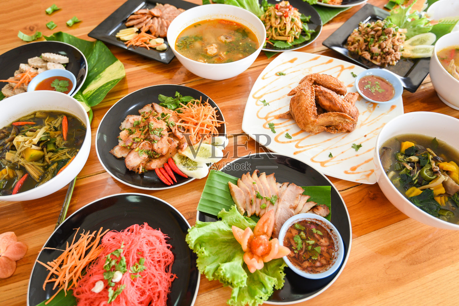 餐桌上的食物盛在盘子里/传统东北食物美味的盘子里有新鲜的蔬菜-许多种类的泰国菜单亚洲食物放在一个木制的桌子上照片摄影图片