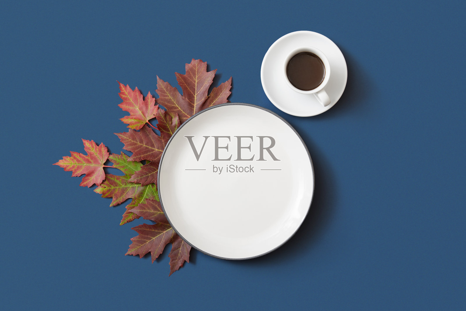 秋空早餐盘和咖啡杯在蓝色背景和橙色枫叶照片摄影图片