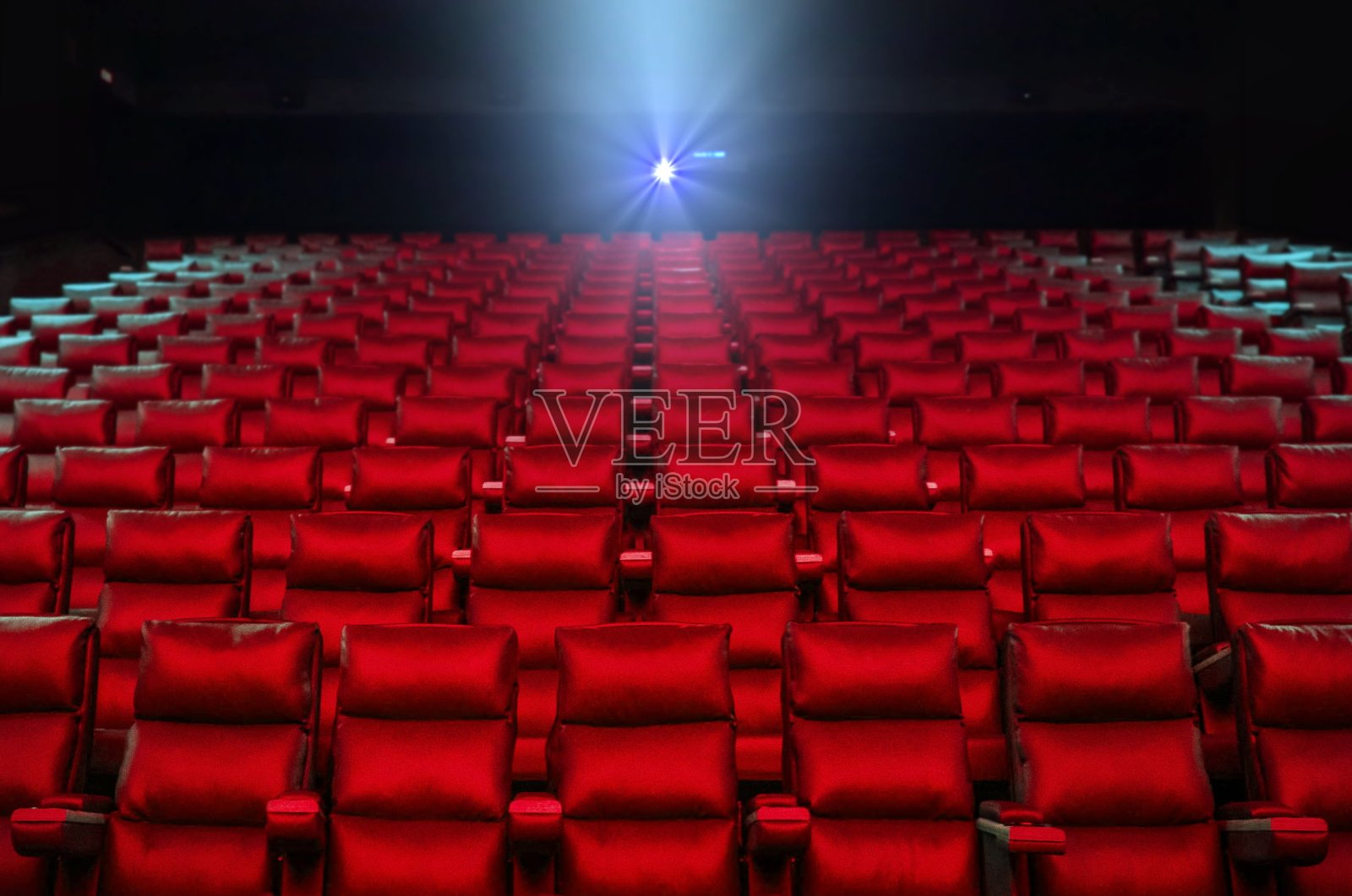 影院座位与放映机明亮的灯光照片摄影图片
