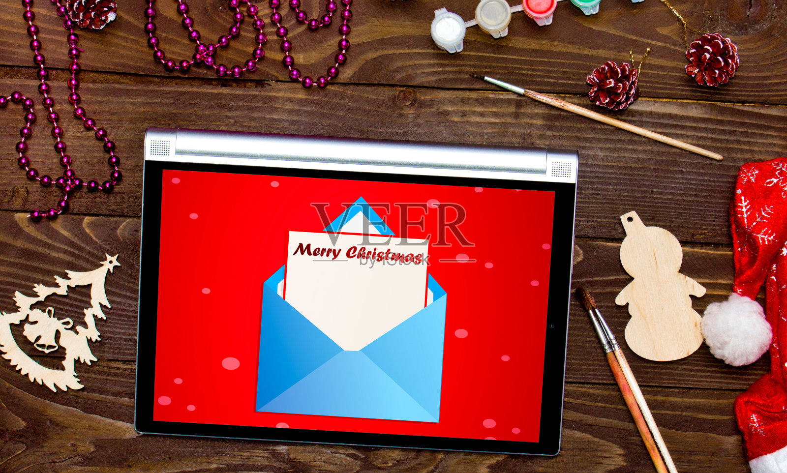 圣诞快乐，在平板电脑上收到一封邮件。圣诞背景模板。照片摄影图片