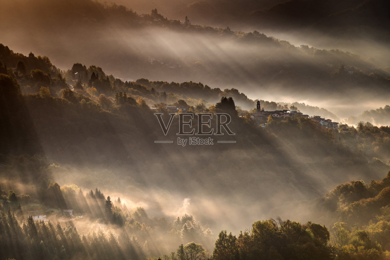 日出晨雾在意大利阿尔卑斯山的小村庄，皮埃蒙特，费内拉山照片摄影图片