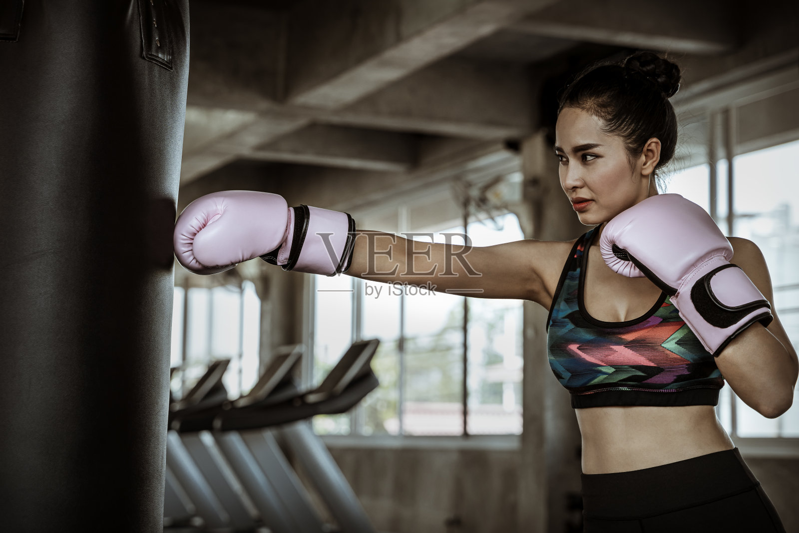 美丽的亚洲女性在健身房打沙袋，锻炼思想，减肥，锻炼肌肉和自卫。照片摄影图片
