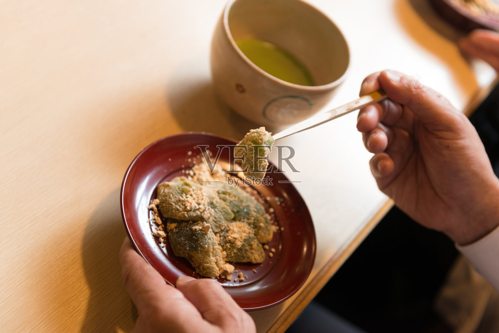 在京都一家餐厅里，日本资深男子正在吃Warabimochi甜点照片摄影图片