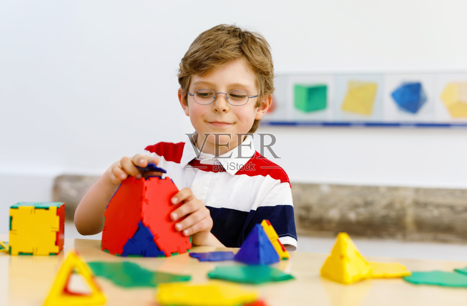 快乐的孩子男孩与眼镜有乐趣的建筑和创建几何图形，学习数学和几何照片摄影图片
