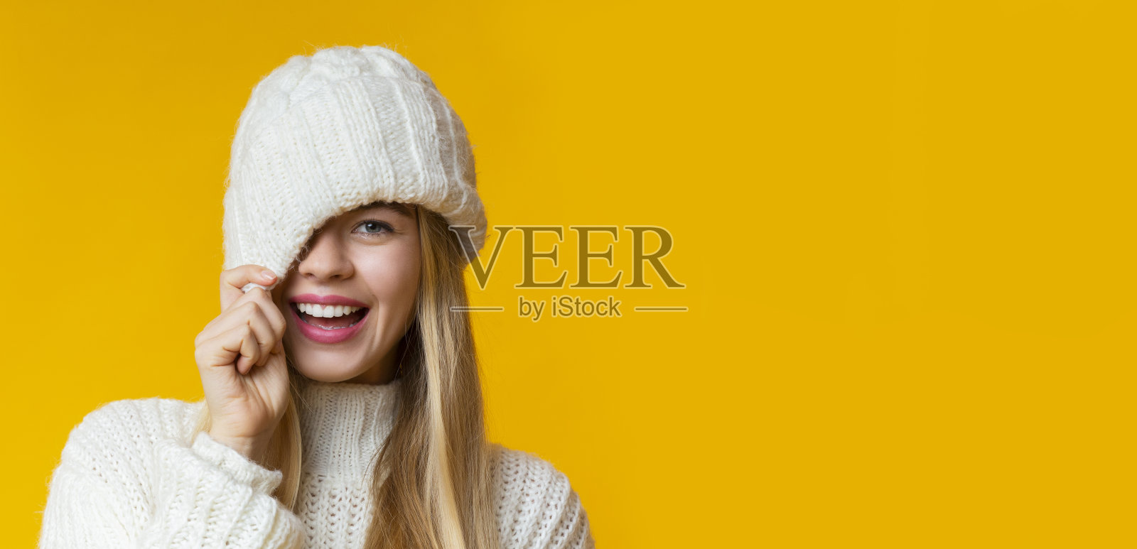 肖像的女孩在冬天的帽子调情黄色的背景照片摄影图片