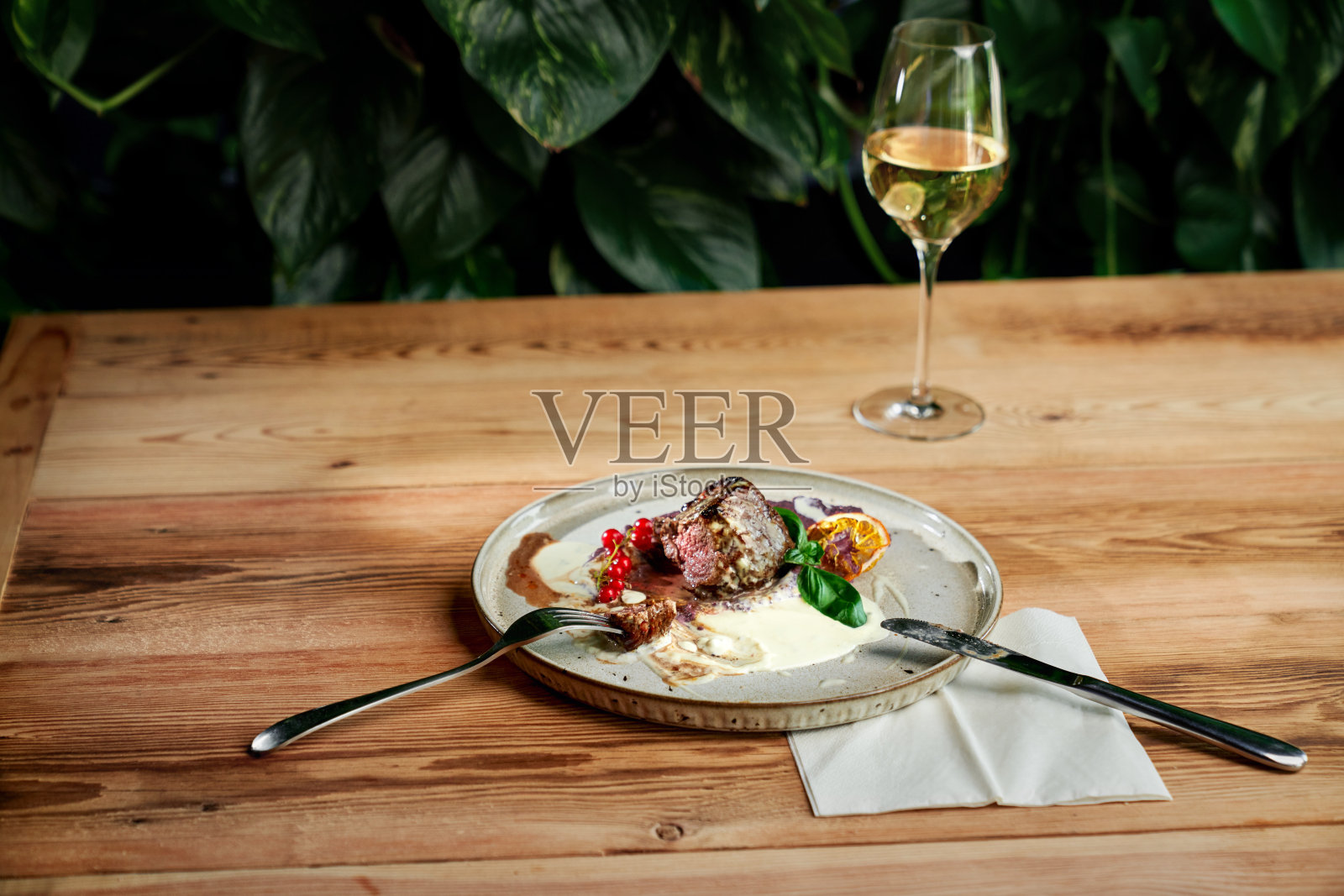 餐厅里的盘子里的烤鸭和白葡萄酒。照片摄影图片