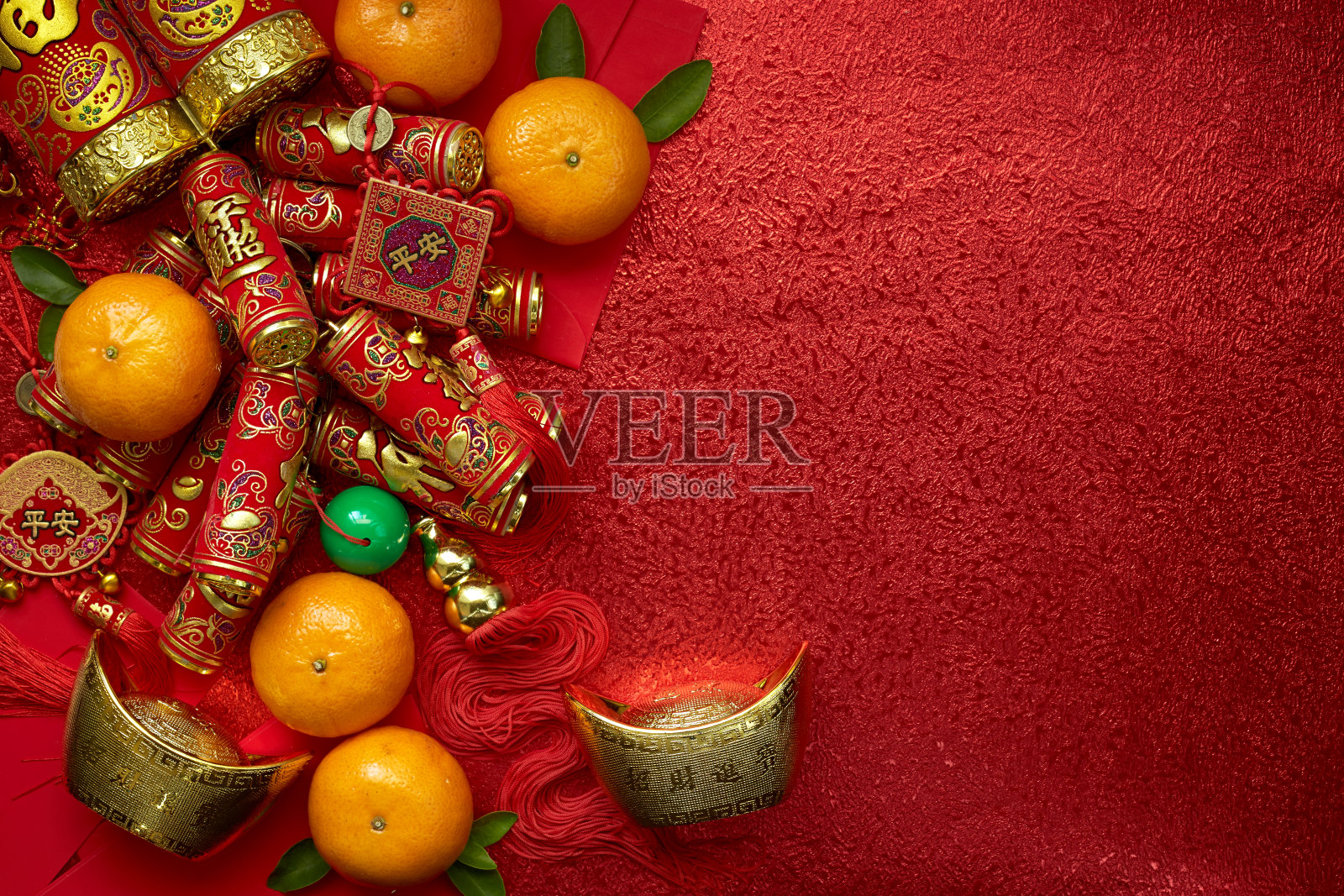中国的硬币或中国结和中国金元宝和传统的中国结(外国文字意味着祝福)和红色的信封和装饰与新鲜的橙子在红色的背景照片摄影图片