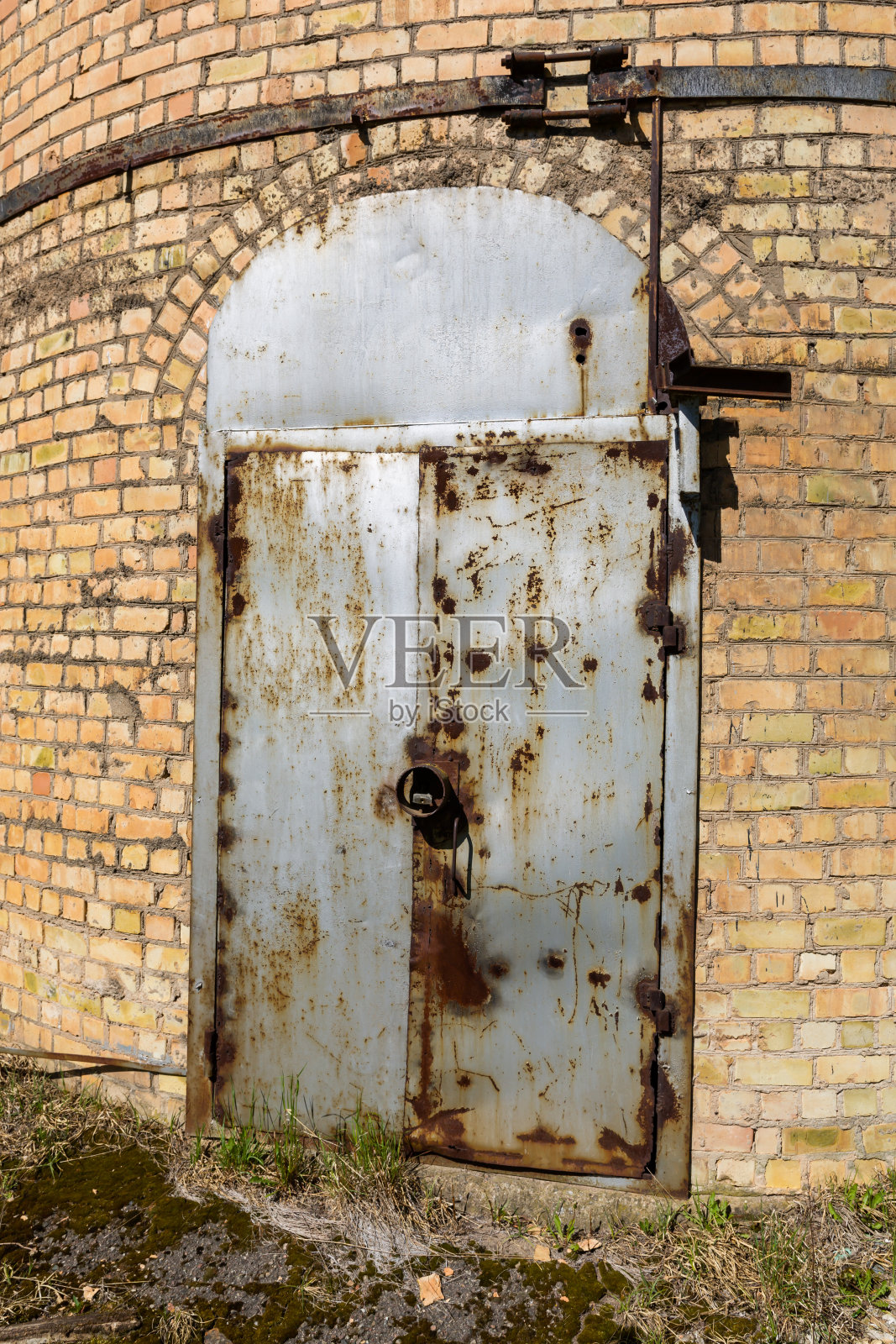 重型工业锈迹斑斑的门在旧仓库靠砖墙照片摄影图片