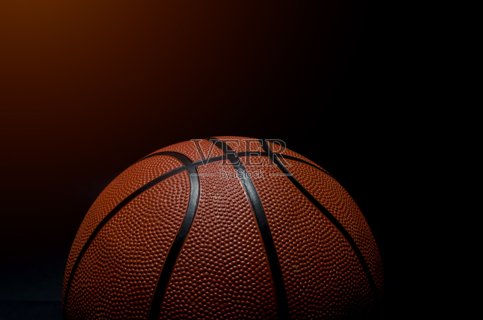 黑色背景上的篮球。照片摄影图片