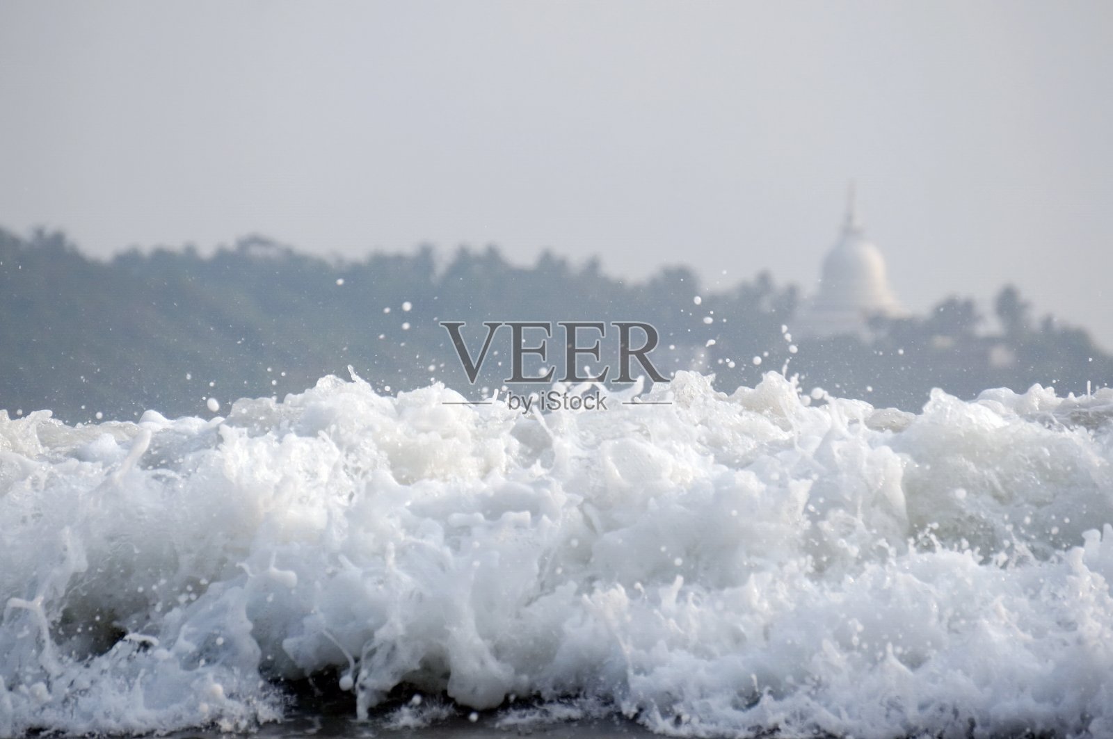在佛教佛塔的背景下，印度洋的波浪。斯里兰卡。照片摄影图片