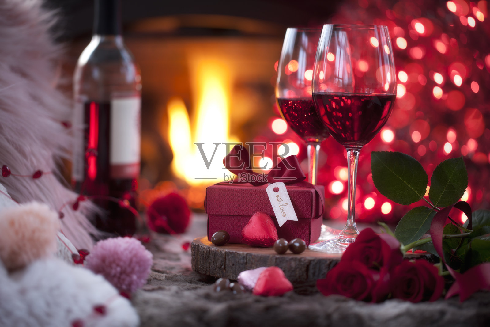 壁炉前放着红酒和巧克力作为情人节礼物照片摄影图片
