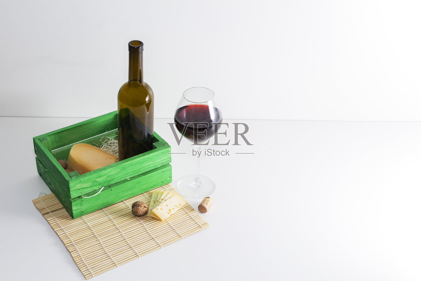 一瓶红酒，一个杯子和一块奶酪。照片摄影图片