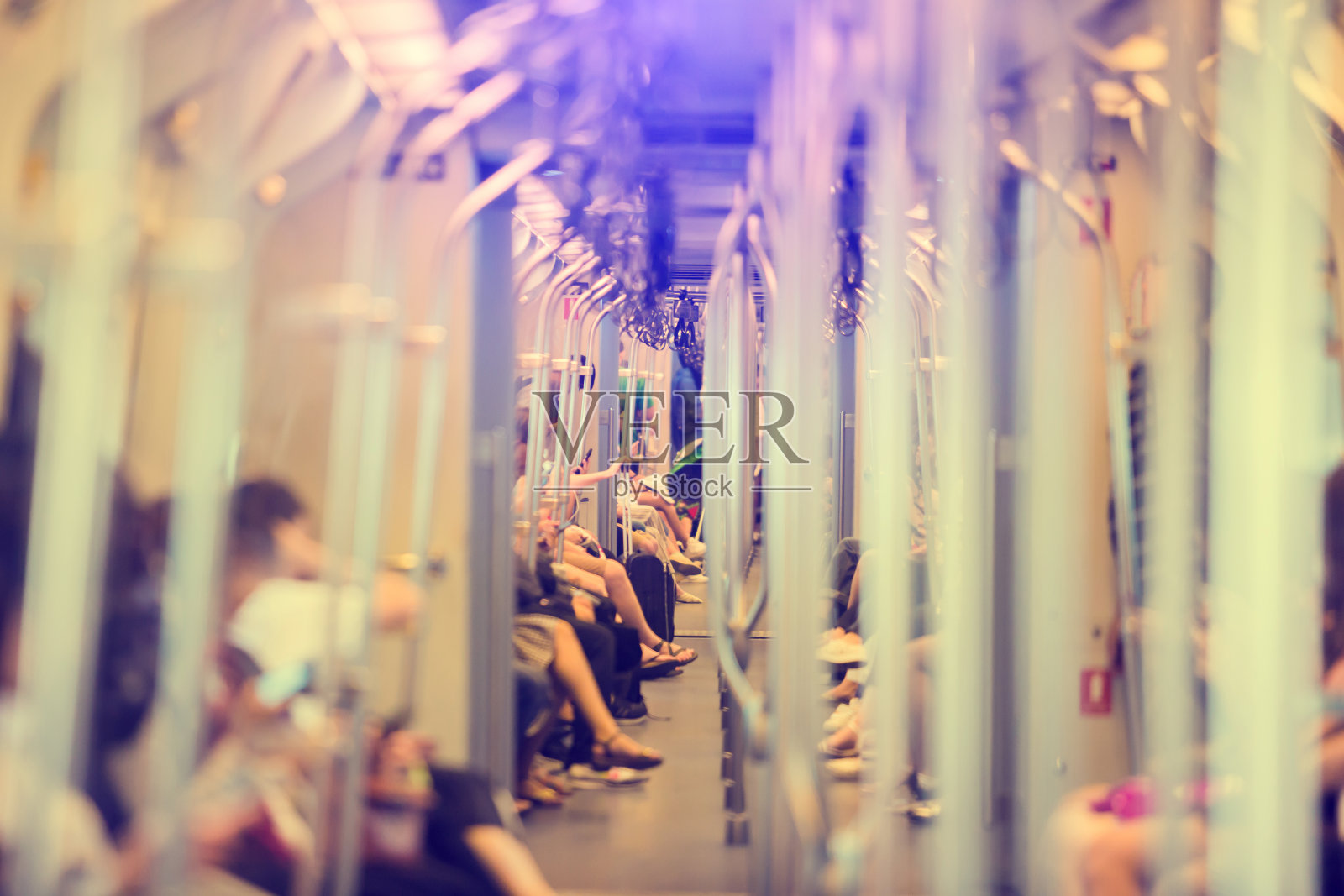 模糊的图像，不锈钢杆和许多乘客坐在玩智能手机的城市社会的日常生活在空中列车。泰国曼谷防弹少年团。照片摄影图片
