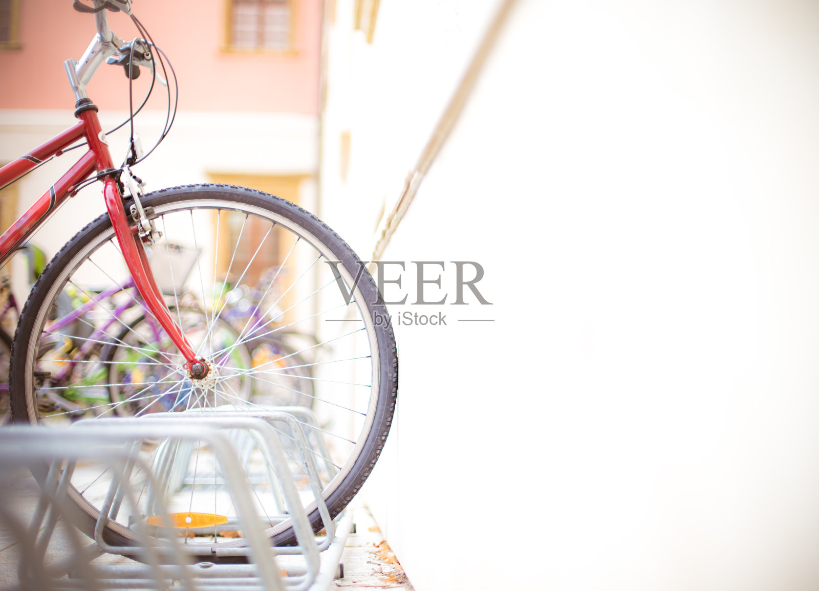 自行车在一个架子在城市附近的白墙照片摄影图片