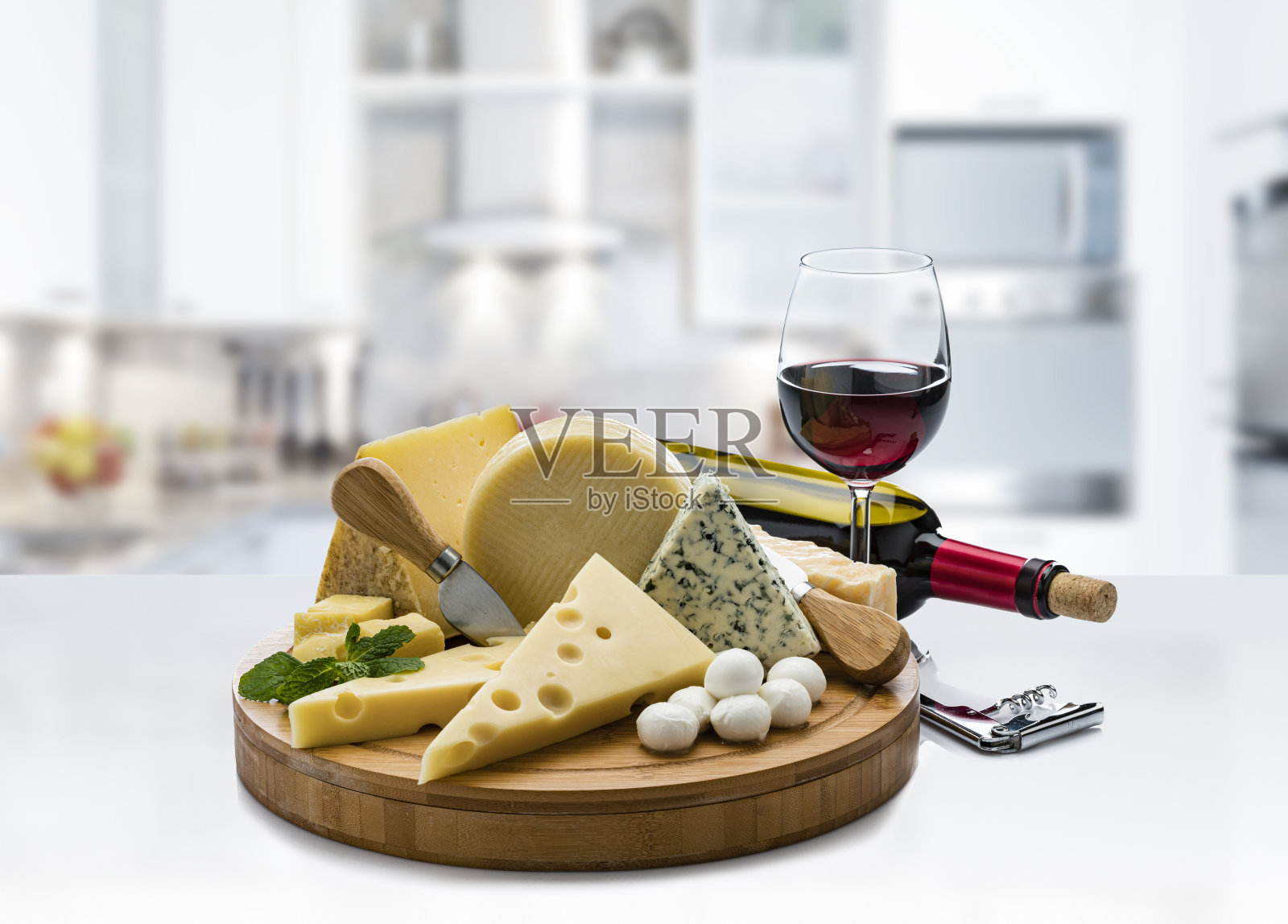 奶酪和葡萄酒:现代厨房台面上的奶酪拼盘和红酒照片摄影图片