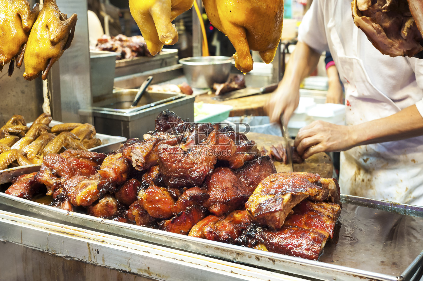 在香港的一个肉摊上，屠夫正在切叉烧肉照片摄影图片
