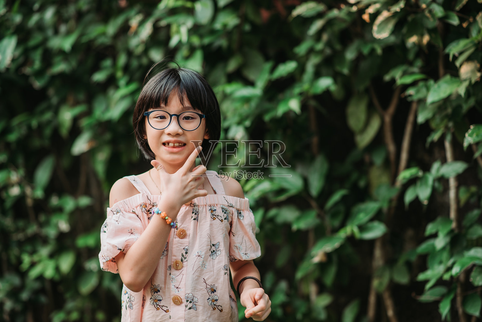 亚洲中国小女孩在她的花园房子微笑着看着相机照片摄影图片