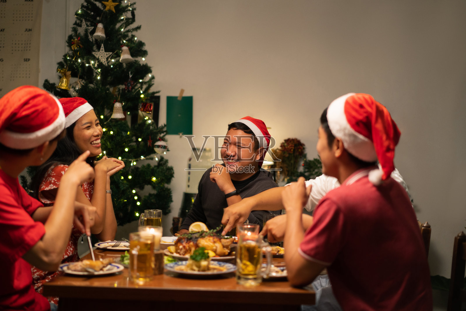 一群亚洲人在家里举行晚宴并喝啤酒。照片摄影图片