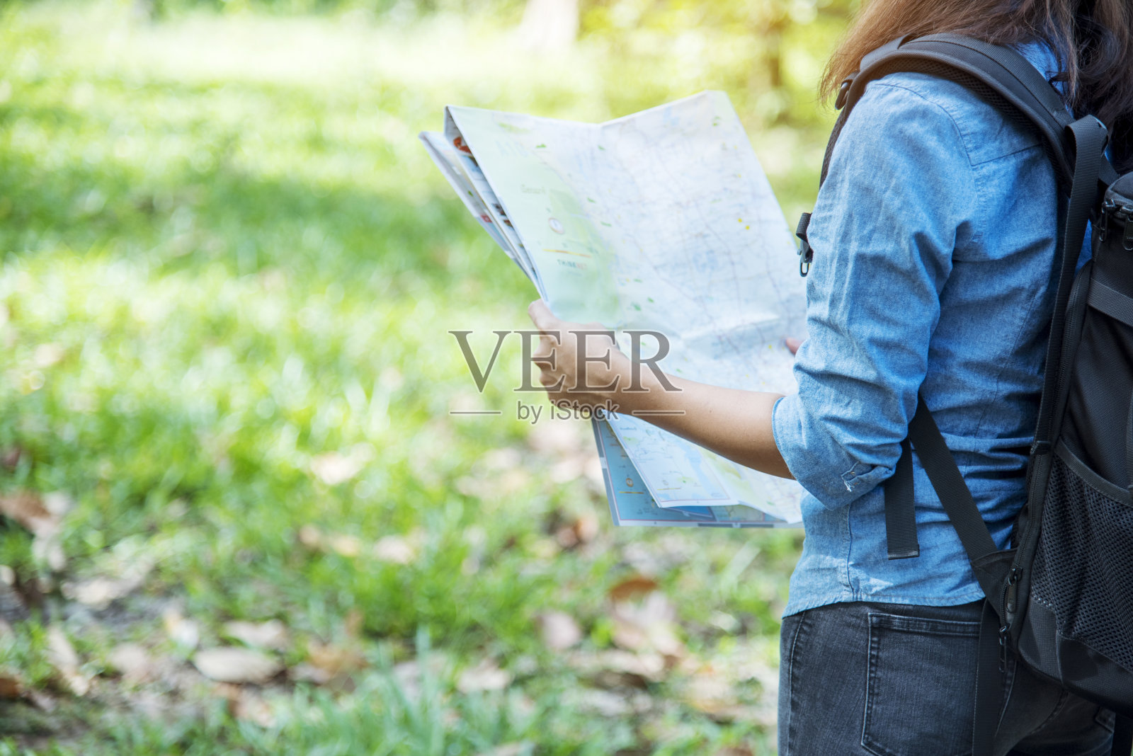 女性旅行者利用地图在绿色自然公园独自徒步快乐，无忧无虑地享受背包户外生活方式。亚洲女性旅行者在旅行的梦想目的地与背包潮人旅程照片摄影图片