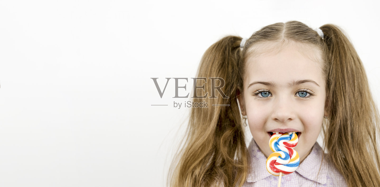 美丽的蓝眼睛女孩吃棒棒糖孤立在白色照片摄影图片