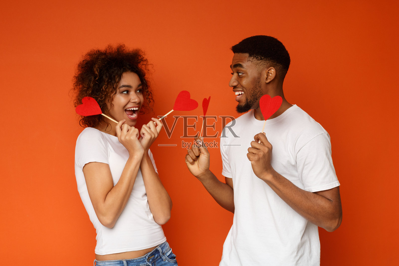 年轻相爱的非裔美国夫妇手持红纸心照片摄影图片