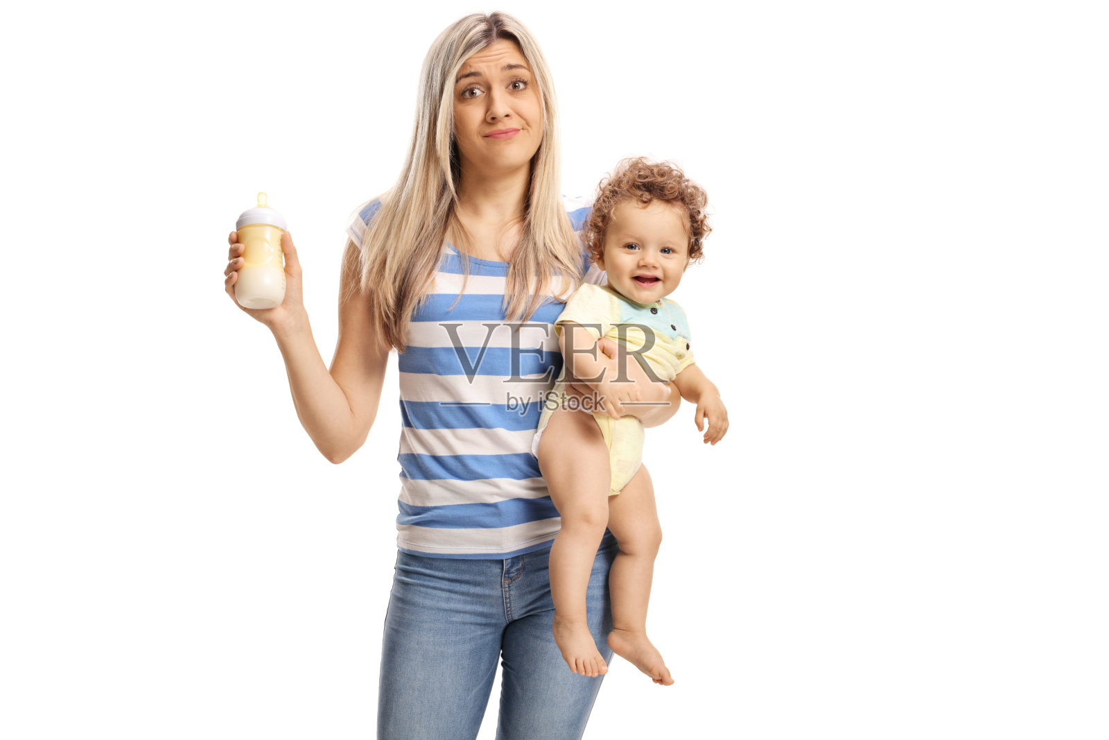 年轻疲惫的母亲抱着一个婴儿和一个奶瓶照片摄影图片
