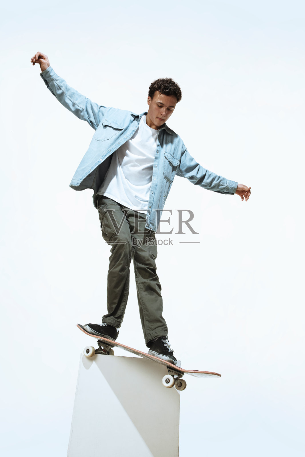 白人年轻的滑板手骑在一个孤立的白色背景照片摄影图片
