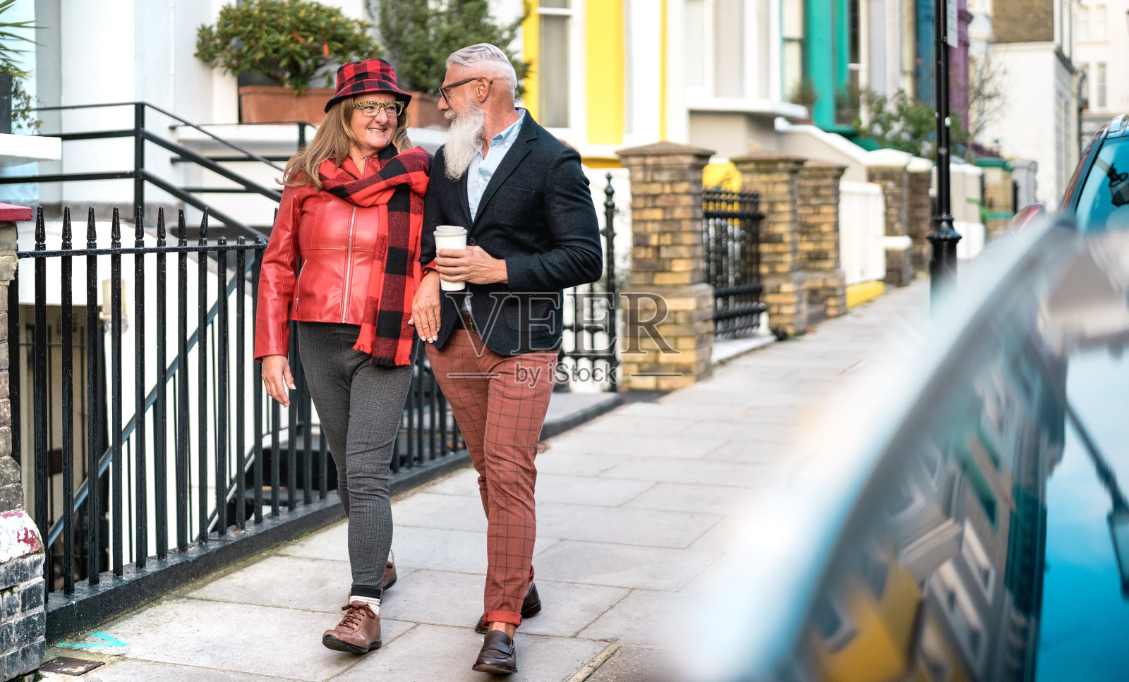 快乐的老年夫妇手牵手在诺丁山在伦敦城-活跃的老年人和旅行的生活方式概念与退休的成年人在英国公路旅行-生动的滤镜与明亮的色调照片摄影图片