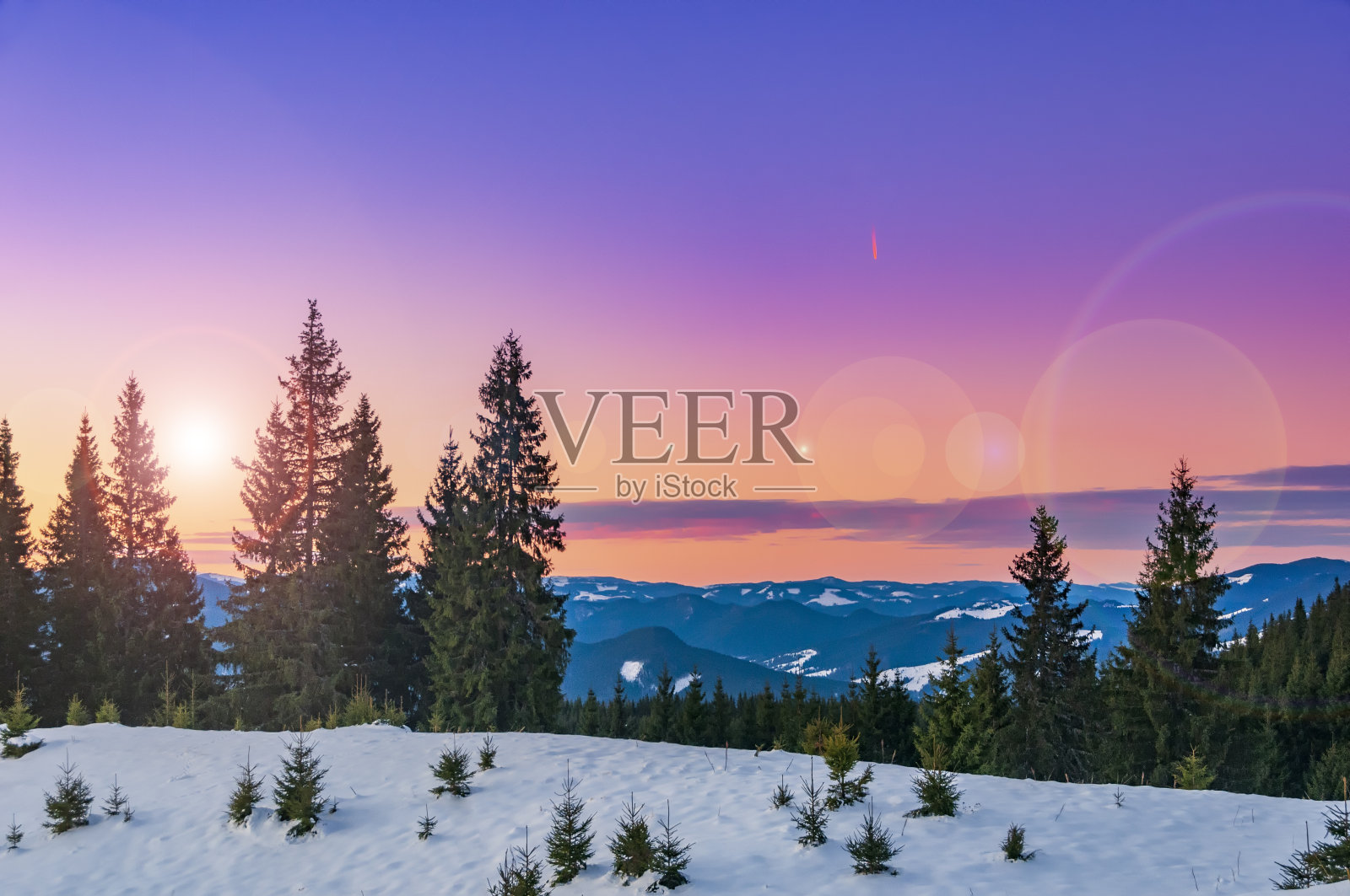 神奇的粉红色日落在高高的冬季山脉。寒冷的冬天晚上照片摄影图片
