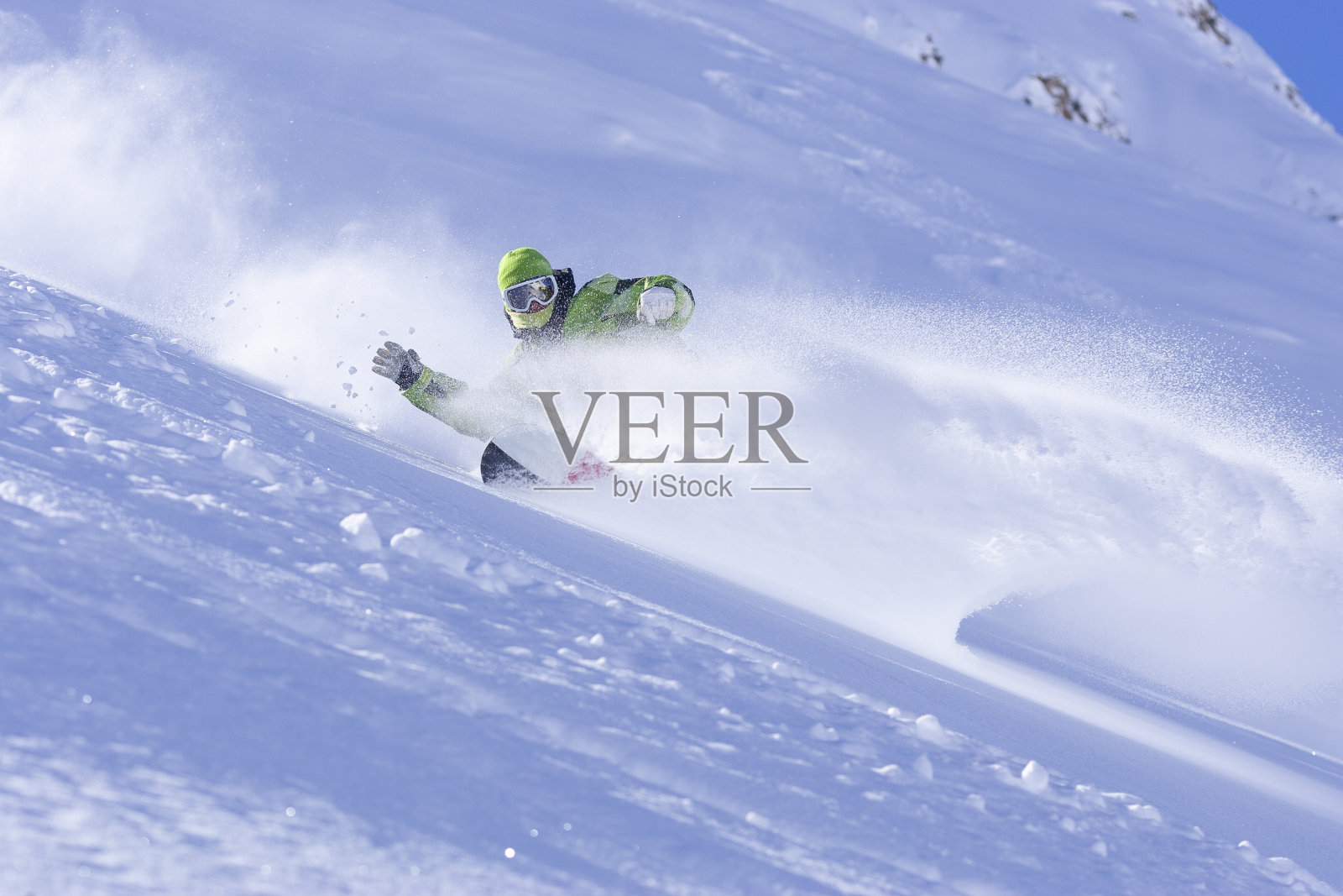 滑雪运动员在粉状雪中转弯。照片摄影图片