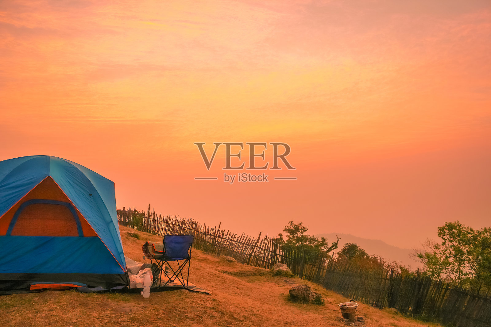 山顶上一个露营帐篷来欣赏晨光、日出和橙色的天空。照片摄影图片