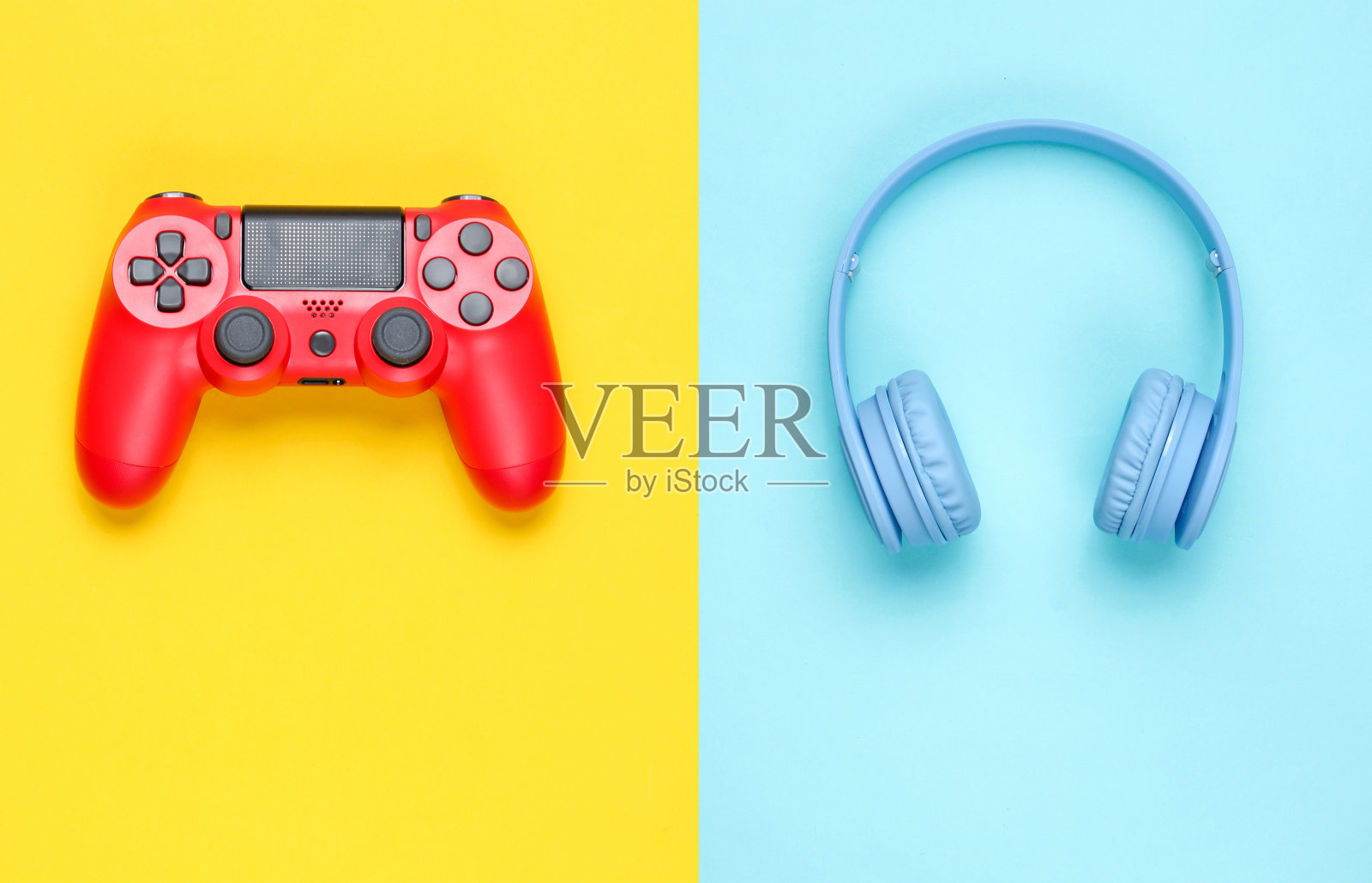 现代蓝色无线耳机和红色手柄在黄蓝色柔和的背景。极简主义。俯视图照片摄影图片