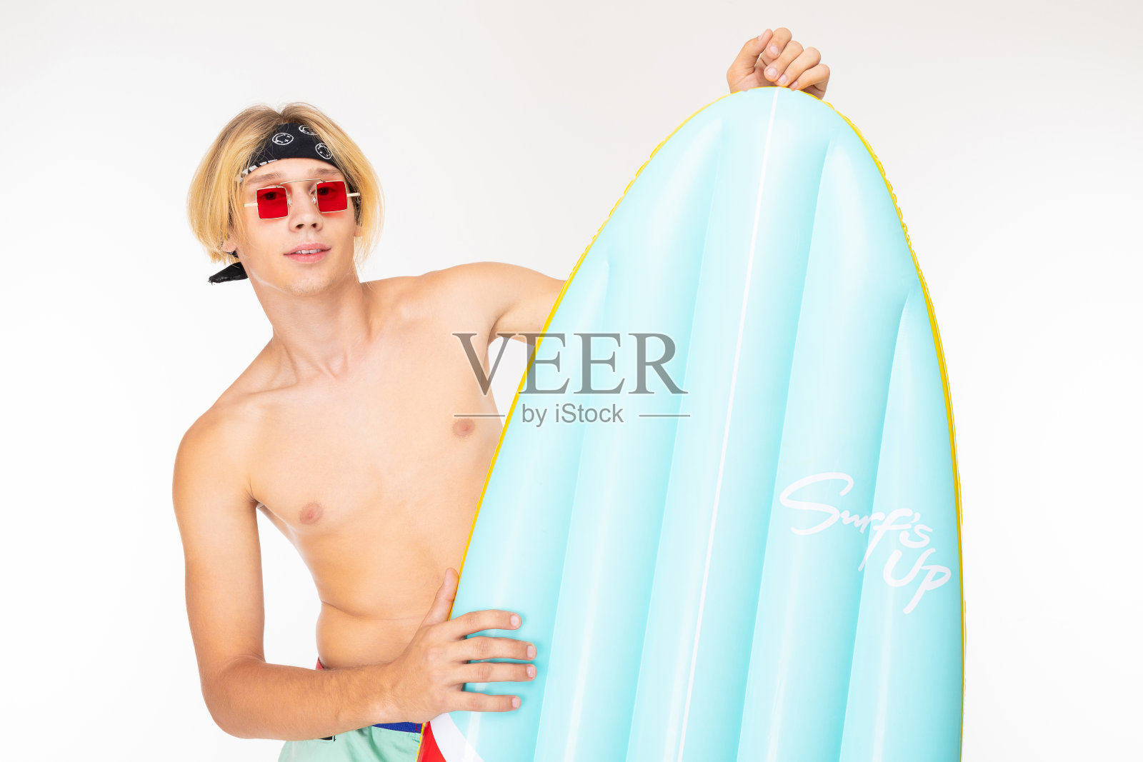 有魅力的金发男人，白色背景上的充气床垫是一个冲浪板照片摄影图片
