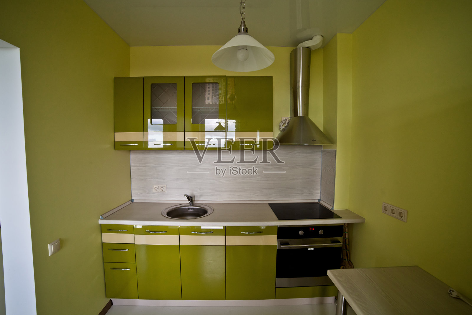 现代厨房的内部采用浅绿色调，配备现代电器照片摄影图片