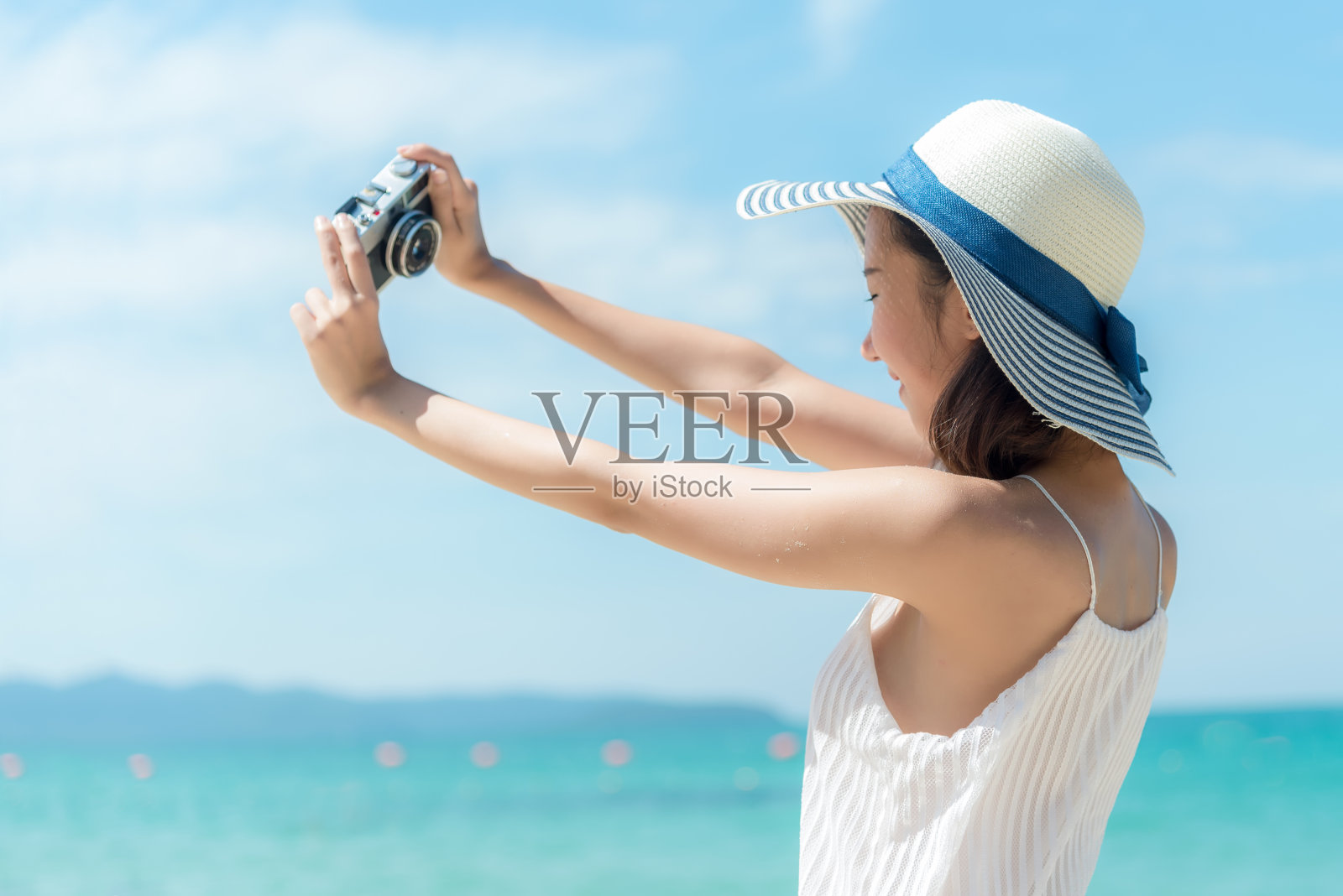 夏天的海滩。生活方式女人放松度假。亚洲的年轻人喜欢拿着相机照片摄影图片