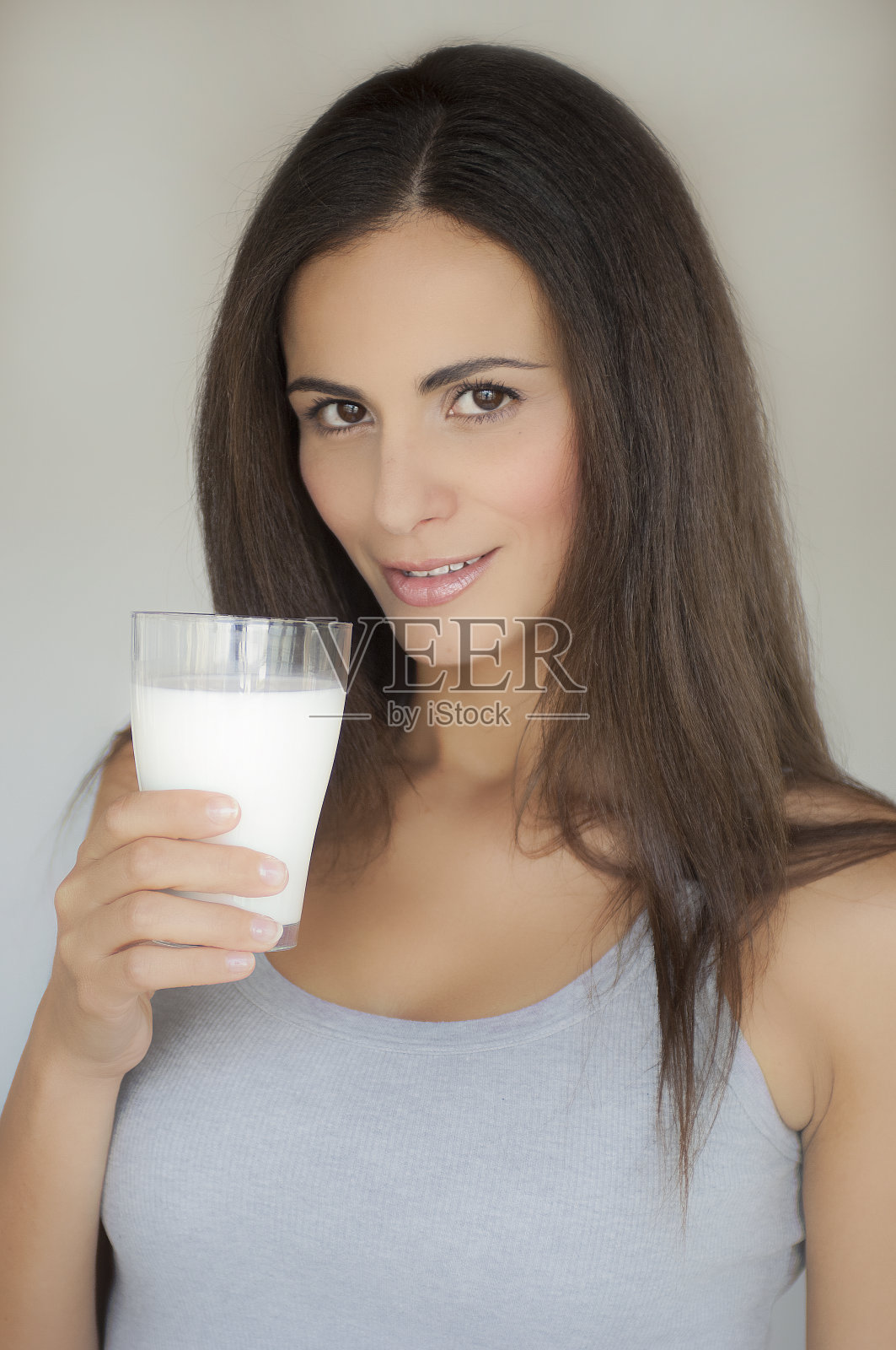 有一头长发的年轻女子，喝着一杯牛奶照片摄影图片