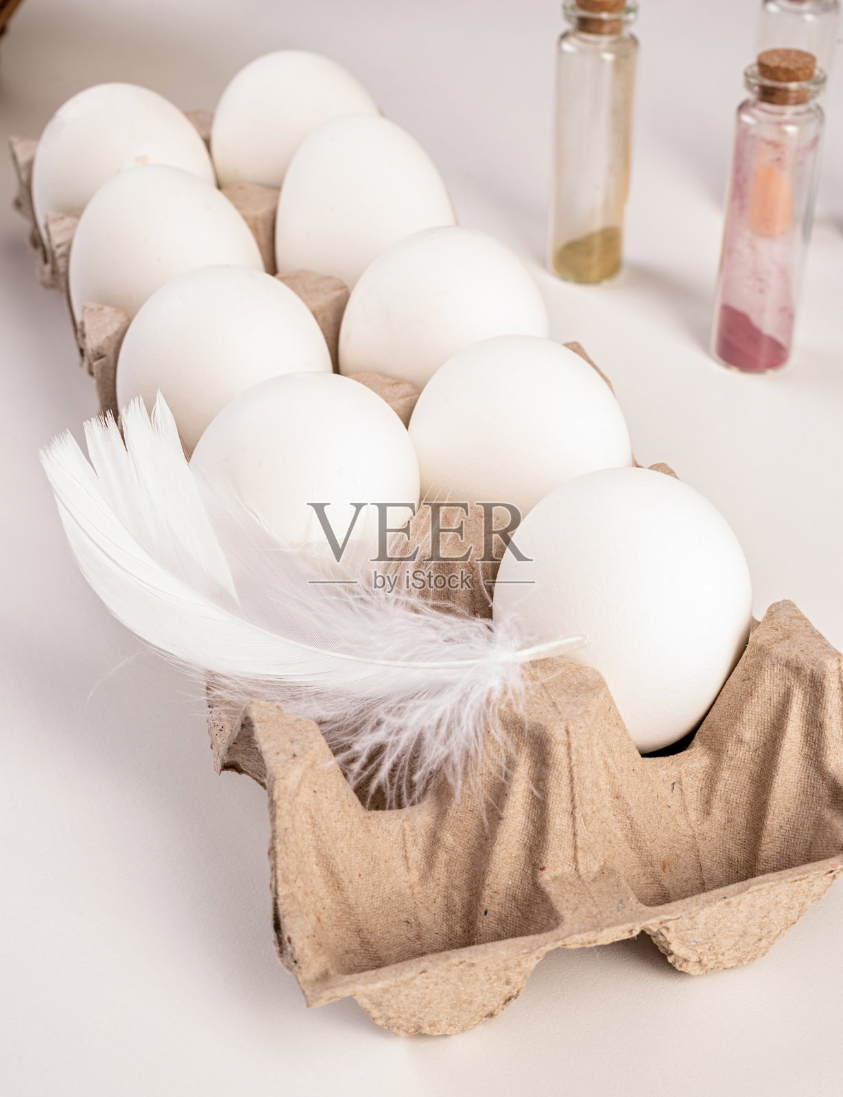新鲜的白色鸡蛋，上面有羽毛，可以上色照片摄影图片