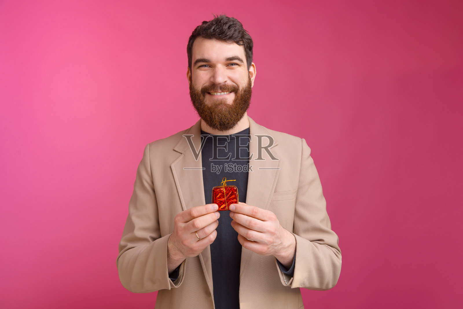 微笑的男人的肖像西装拿着小红色礼物照片摄影图片