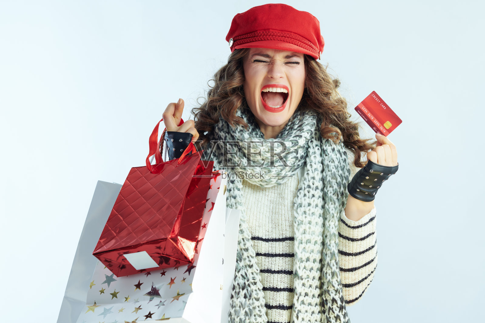 开朗时尚的女人购物者在冬季浅蓝色的背景照片摄影图片