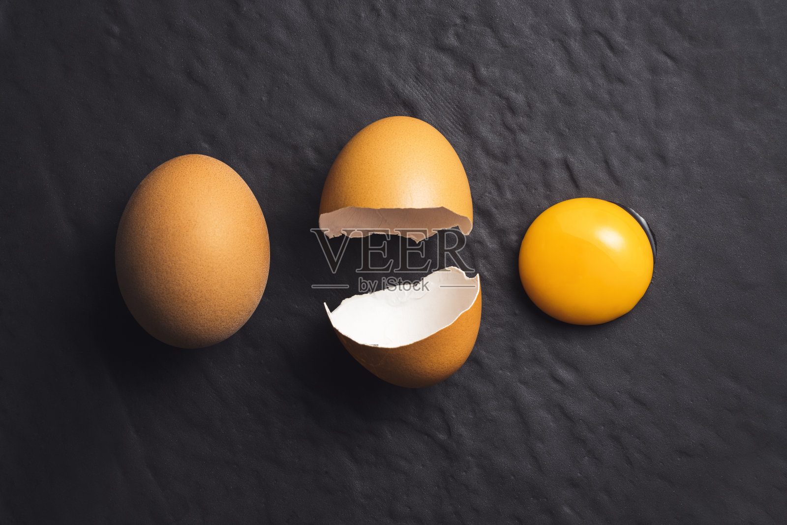 破碎的鸡蛋在黑色纹理的背景照片摄影图片