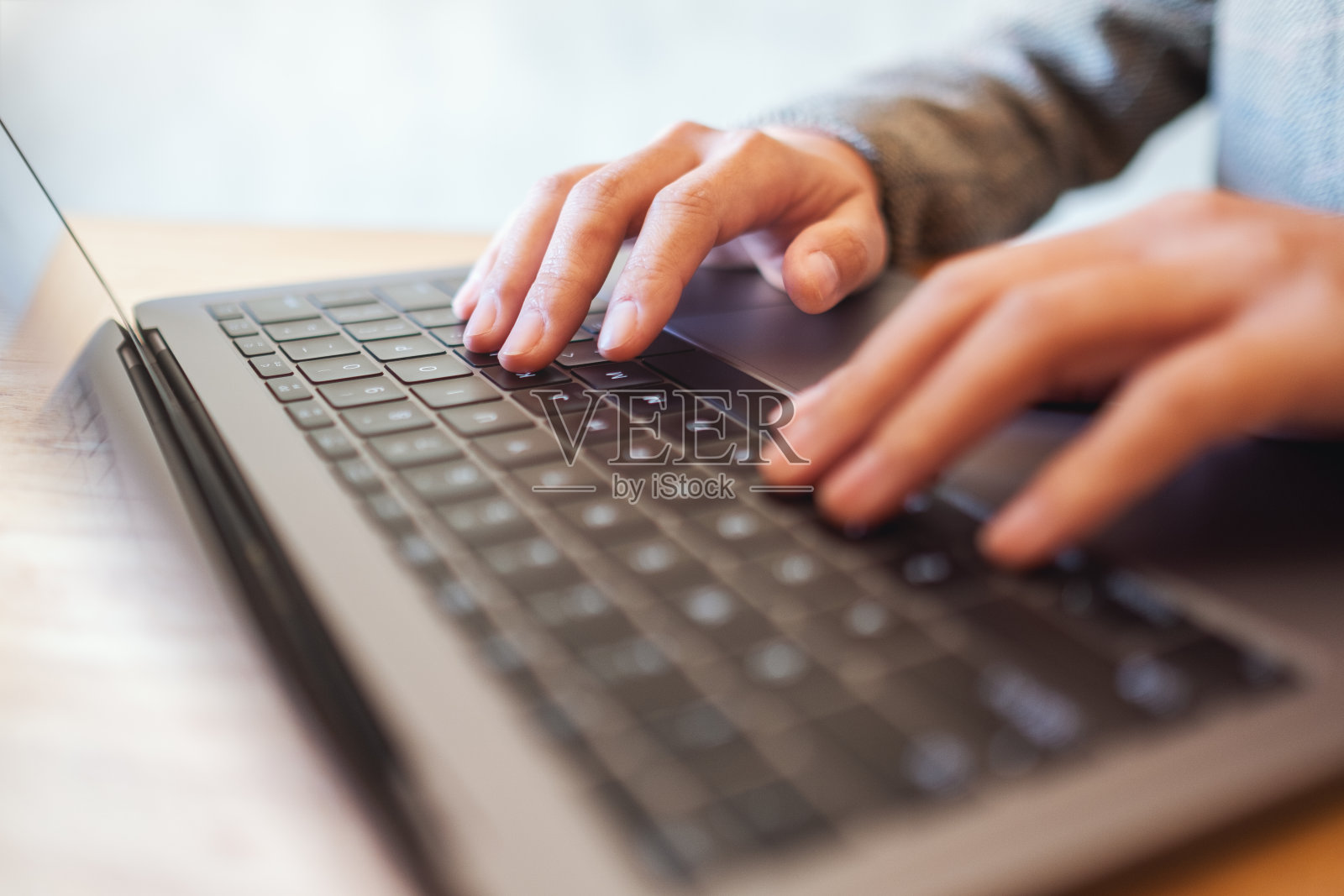 一个工作的女人，在桌上的笔记本电脑键盘上打字照片摄影图片