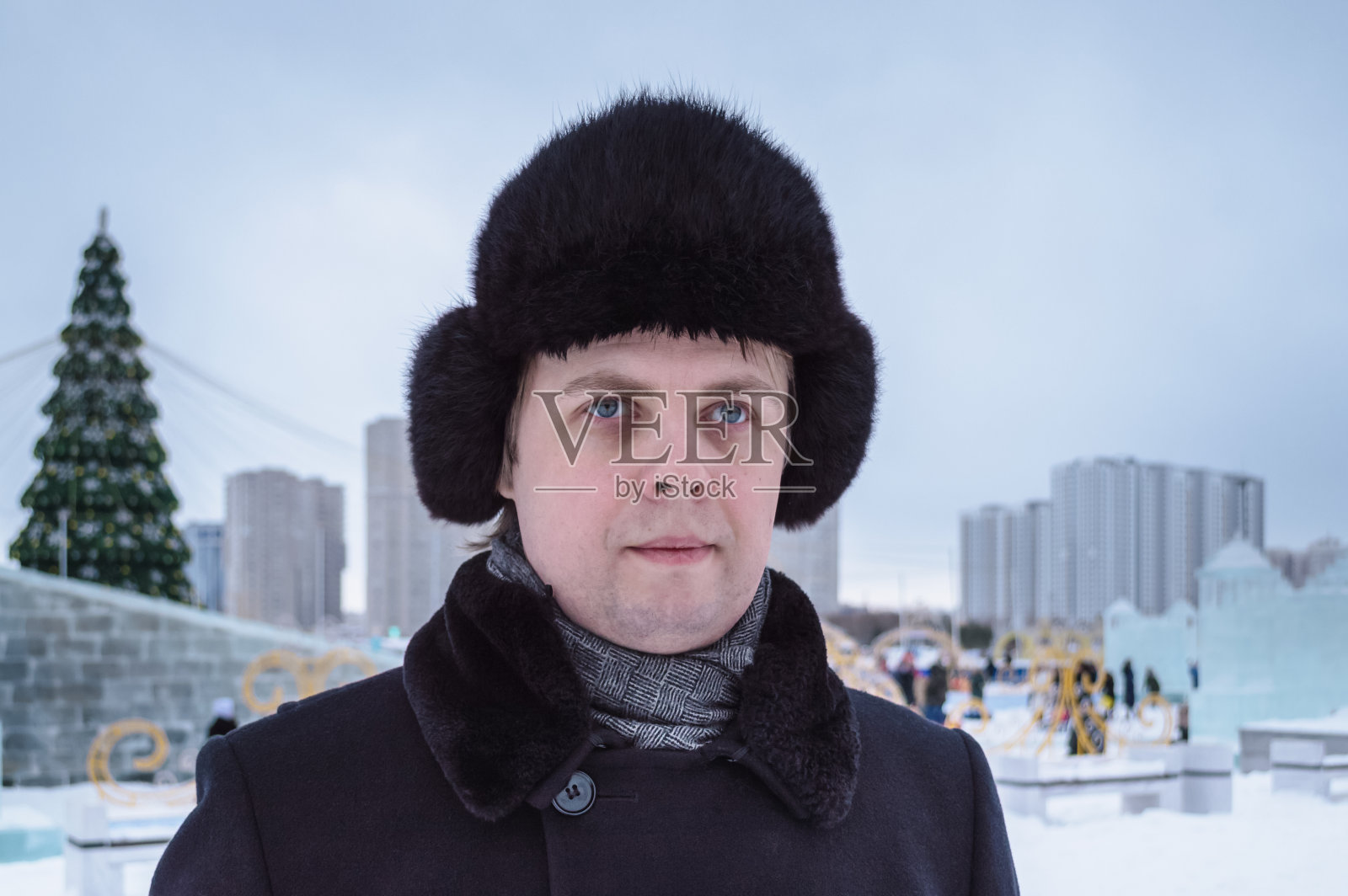 肖像的俄罗斯男子在冬天起床在阴沉的天装饰广场在城市的背景照片摄影图片