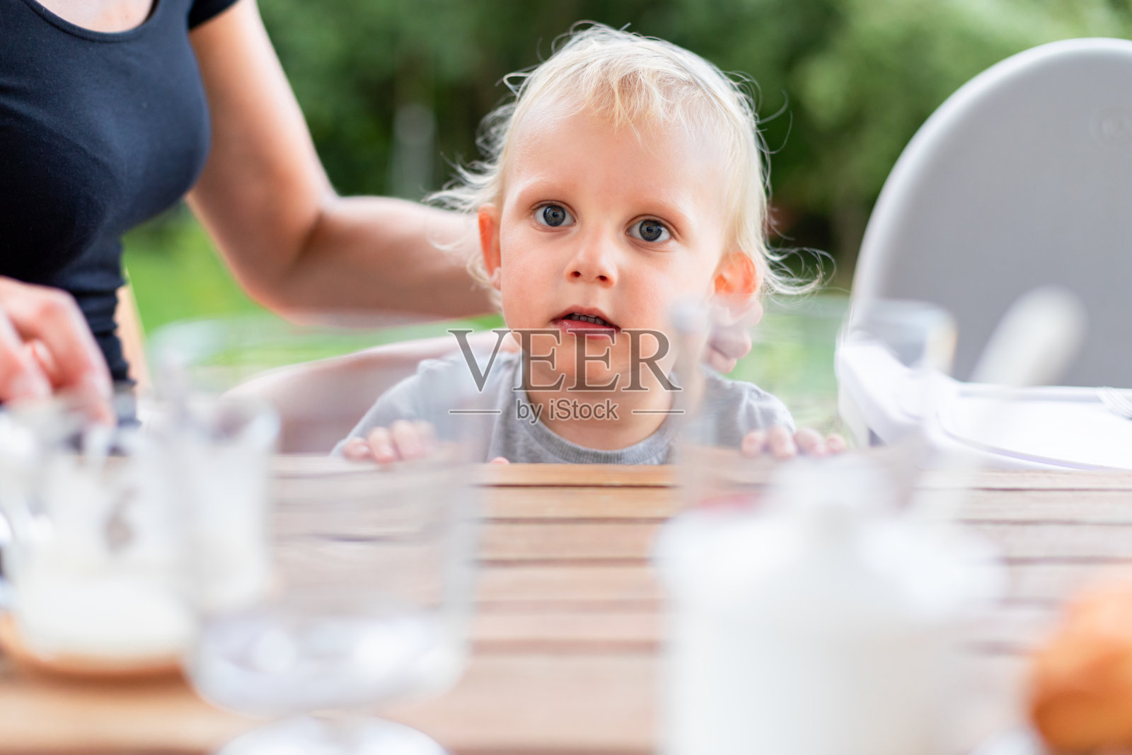 可爱的婴儿坐在餐桌外面照片摄影图片