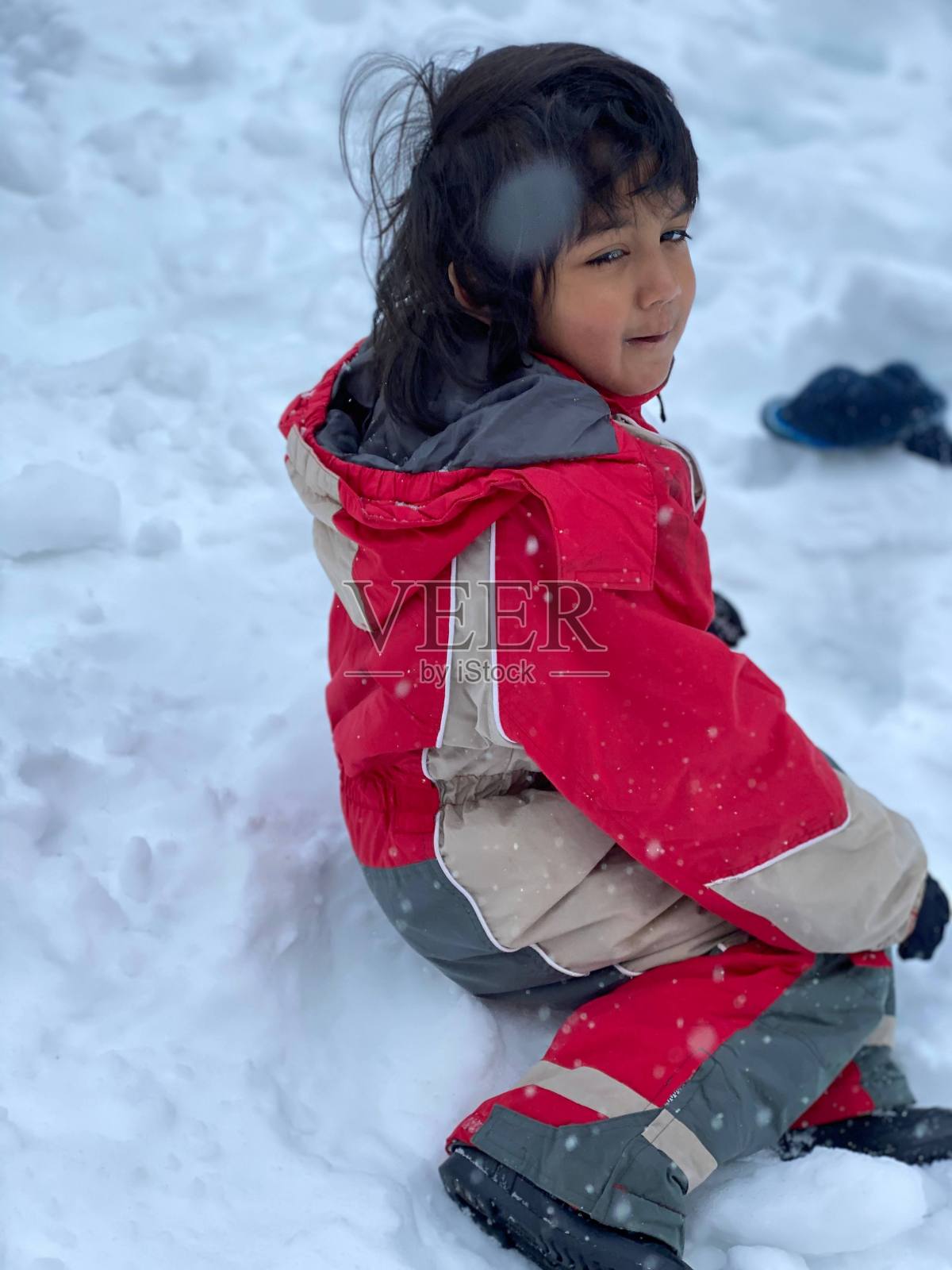 小男孩在雪地里玩得很开心。照片摄影图片