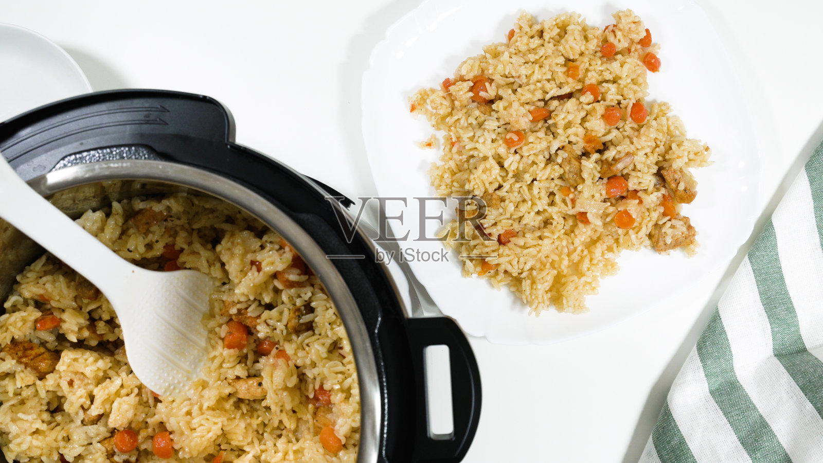 米饭和肉和蔬菜在多锅准备，近距离白色背景，从上面看照片摄影图片