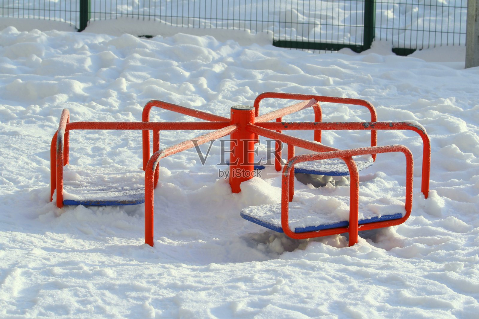孩子们的红色金属旋转木马被雪覆盖照片摄影图片