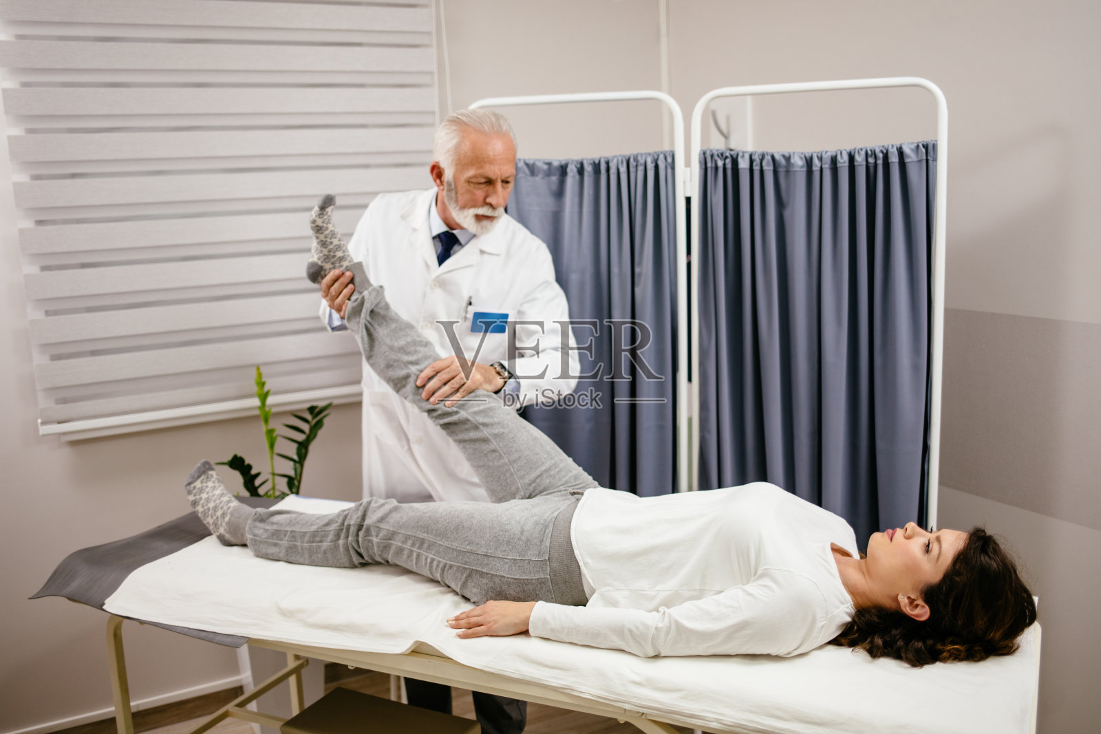 妇女在治疗师的腿部检查照片摄影图片