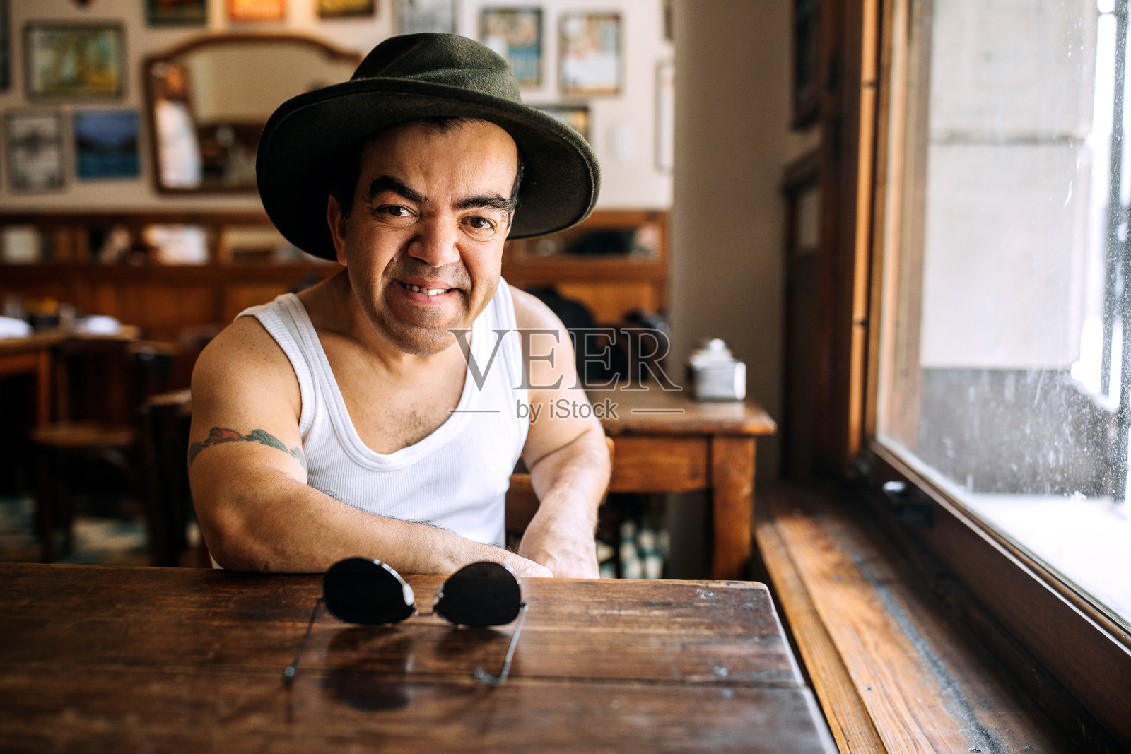 中年男子与侏儒症戴牛仔帽在咖啡馆照片摄影图片