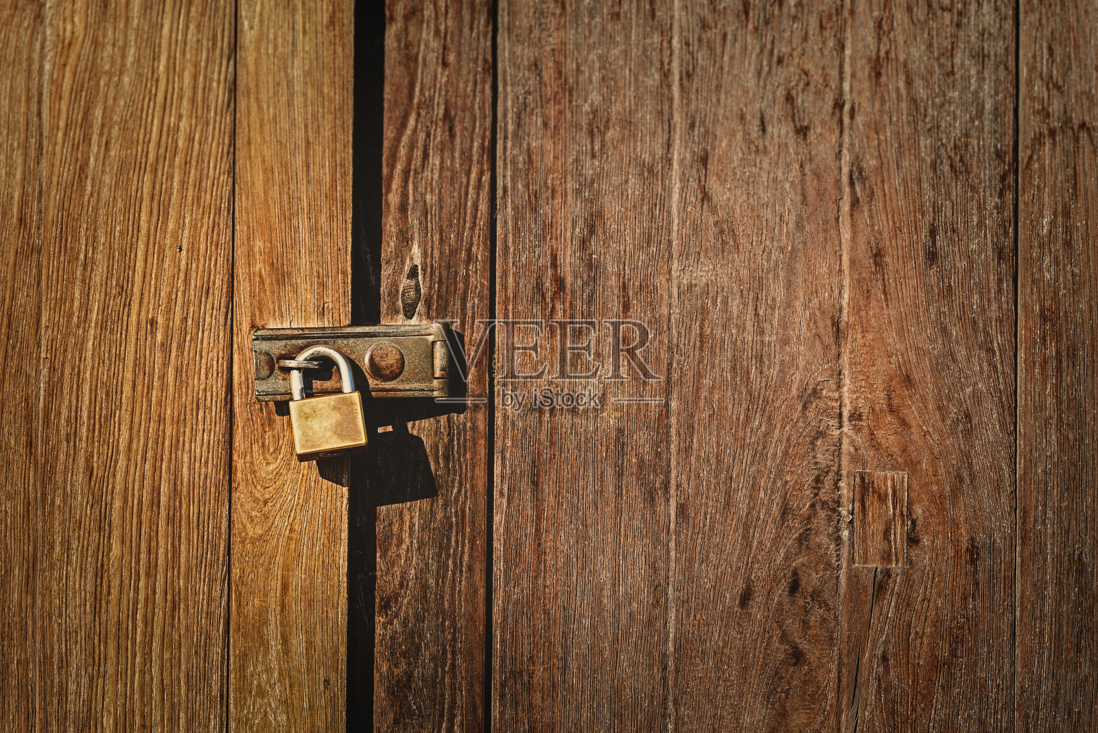 带旧挂锁的木门。照片摄影图片